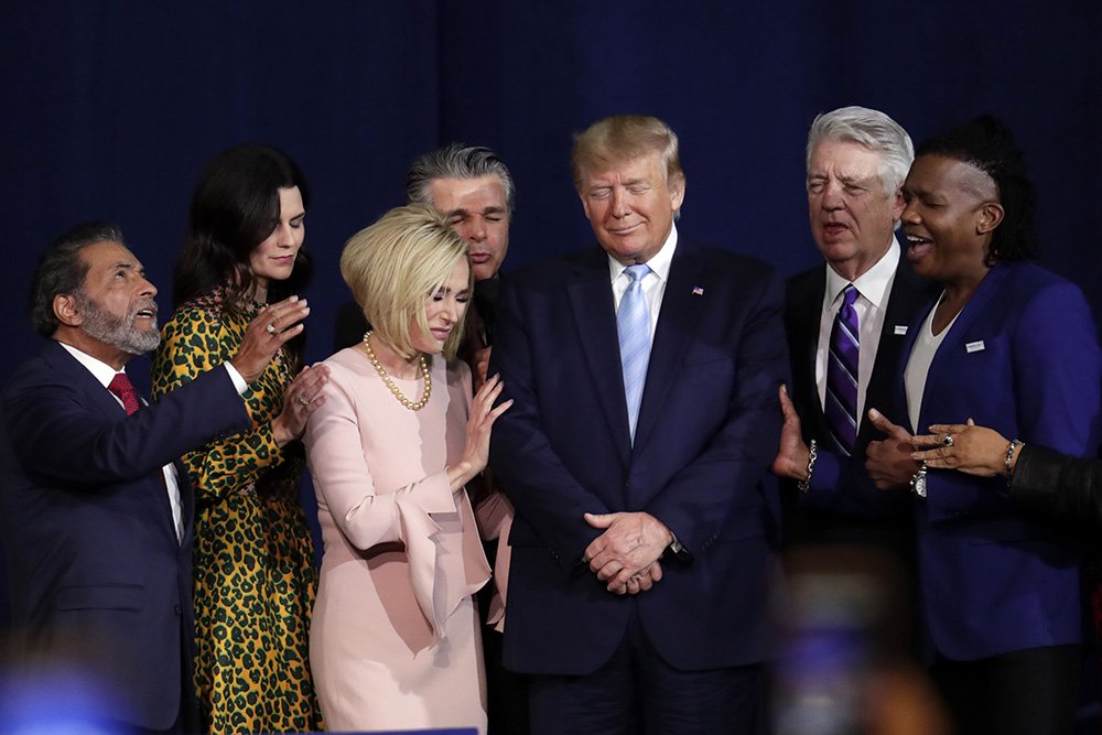 Faith leaders pray with President Donald Trump during a rally for evangelical supporters at the King Jesus International Ministry church on Jan. 3, 2020, in Miami. (AP Photo/Lynne Sladky)
